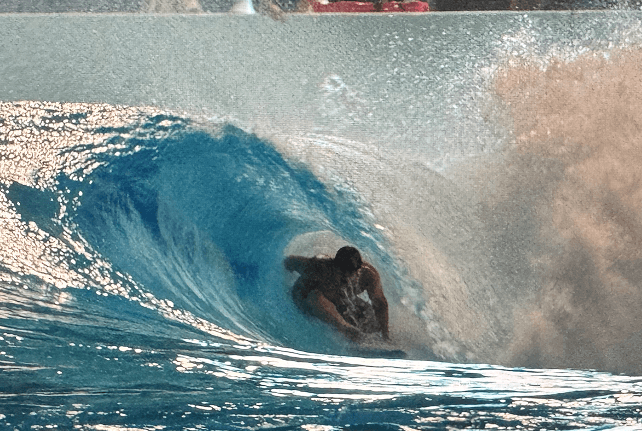 Surfer carving across a wave